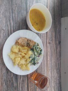 Zdjęcie przedstawia Dietę łatwostrawną: Zupa marchewkowa z zacierką Ziemniaki młode z koperkiem gotowane Łosoś pieczony z przyprawami Mix sałat z jogurtem Kompot owocowy z jabłkami